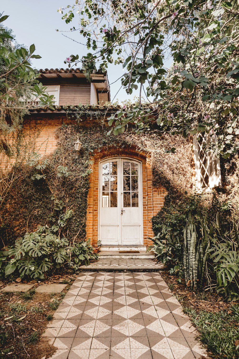 Casa de ladrillo marrón con plantas verdes