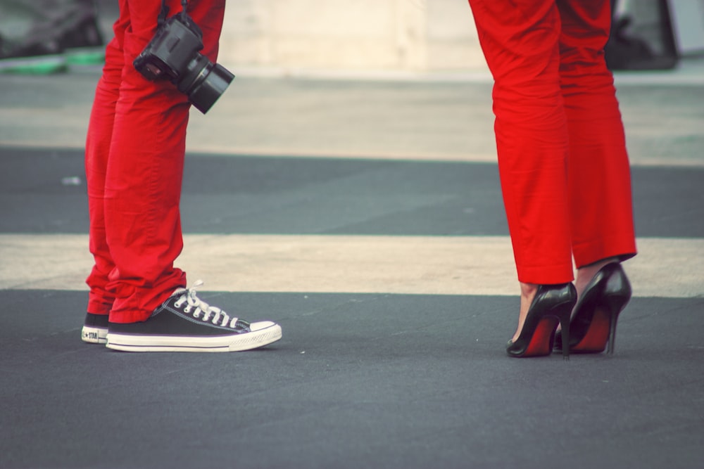 person in red pants and black and white nike sneakers