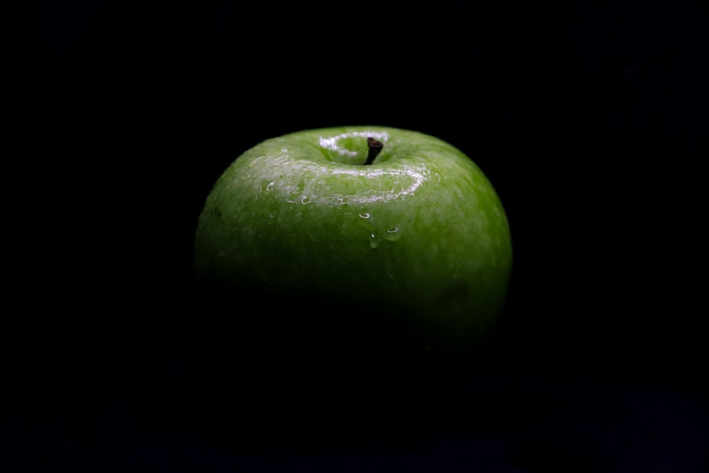 manzana verde sobre fondo negro