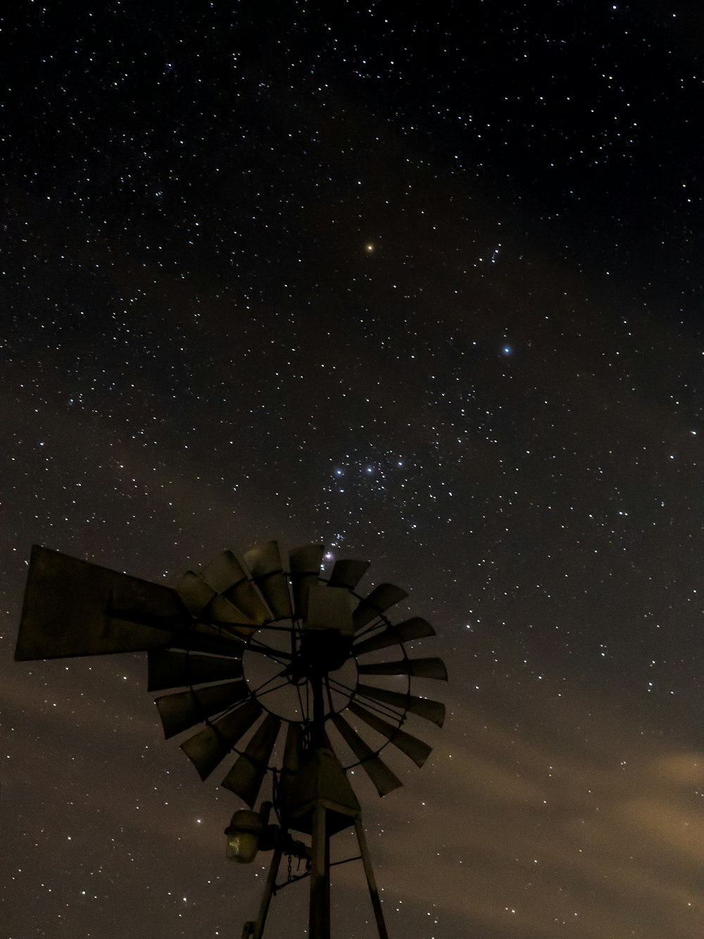 brown wooden windmill under starry night