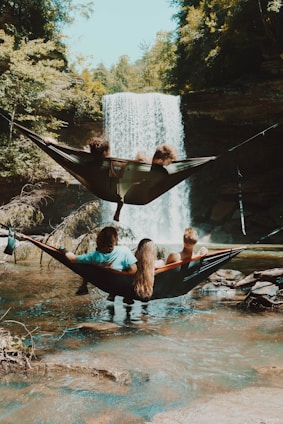 Family on hammocks in front of waterfalls