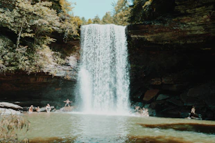 people sitting on water fountain during daytime