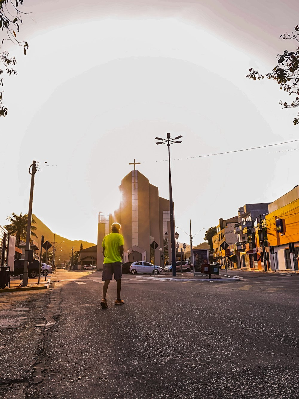 man in green hoodie walking on street during daytime