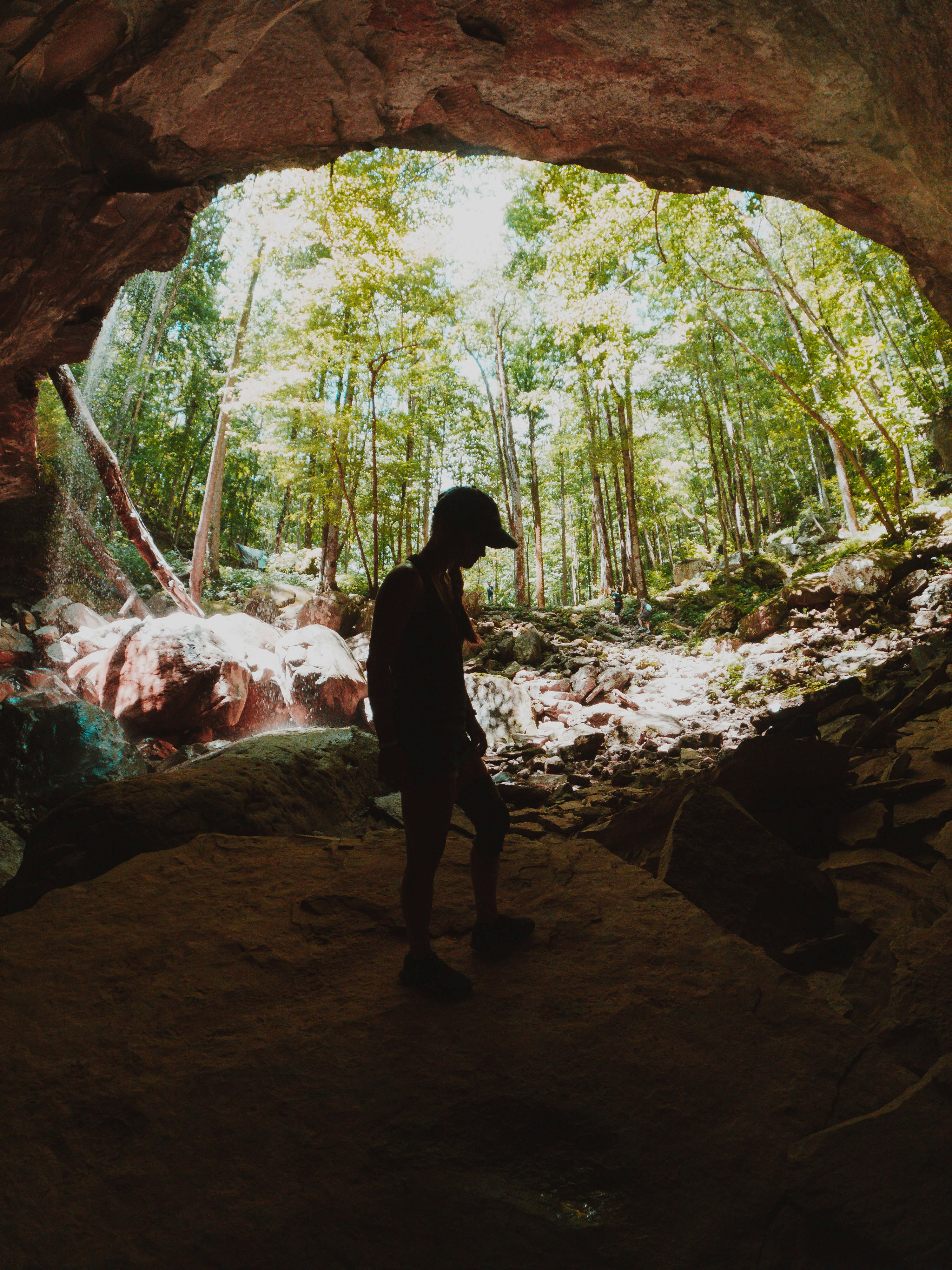 Femme en veste noire marchant sur un chemin de terre brun pendant la journée