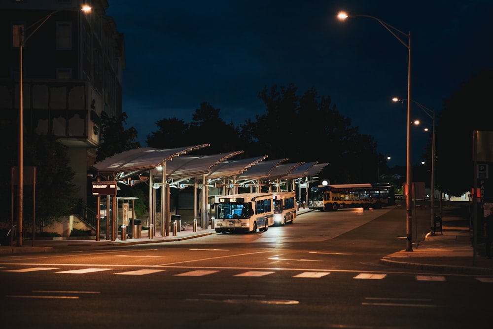 夜間の路上を走る白と茶色の路面電車