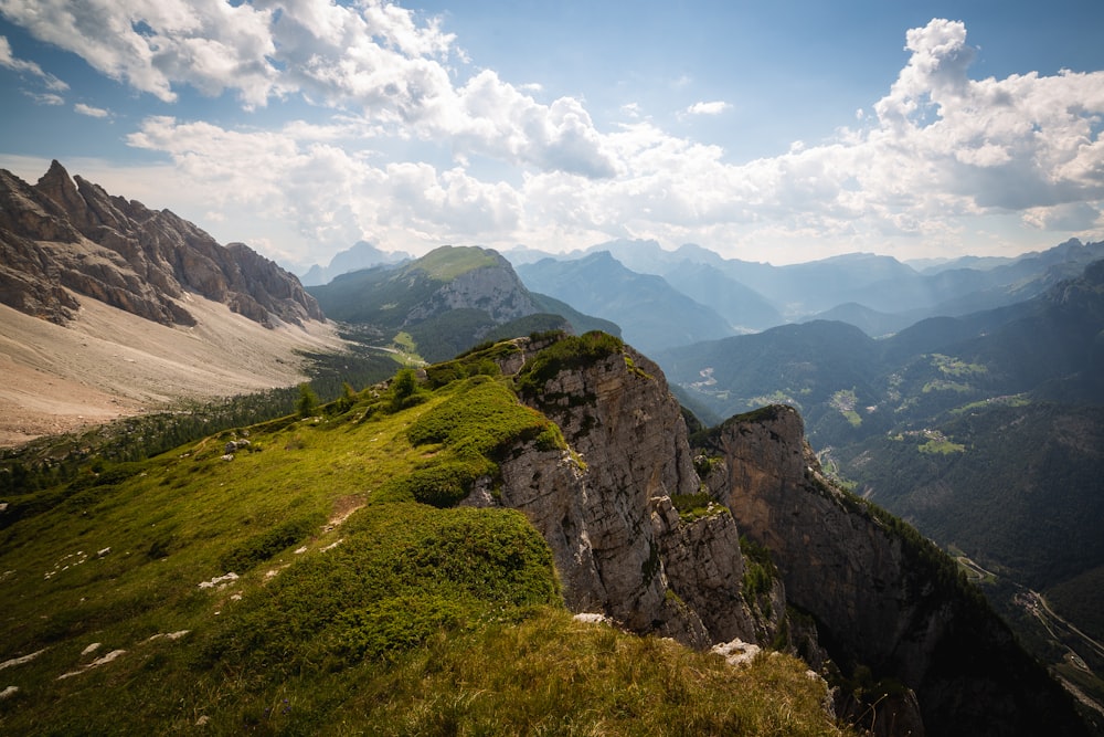 green grass covered mountain under white clouds during daytime