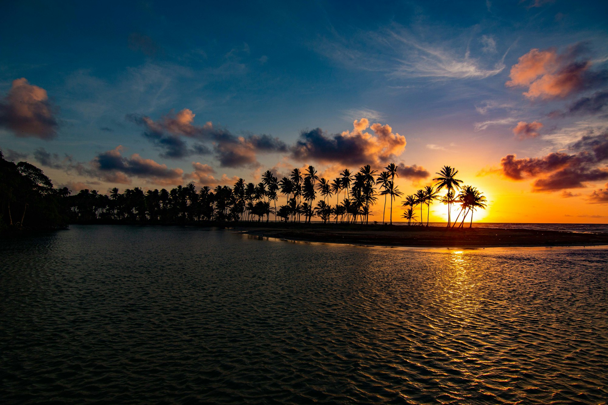 Jungle-covered point curving into calm water at sunset on the Caribbean coast of Costa Rica