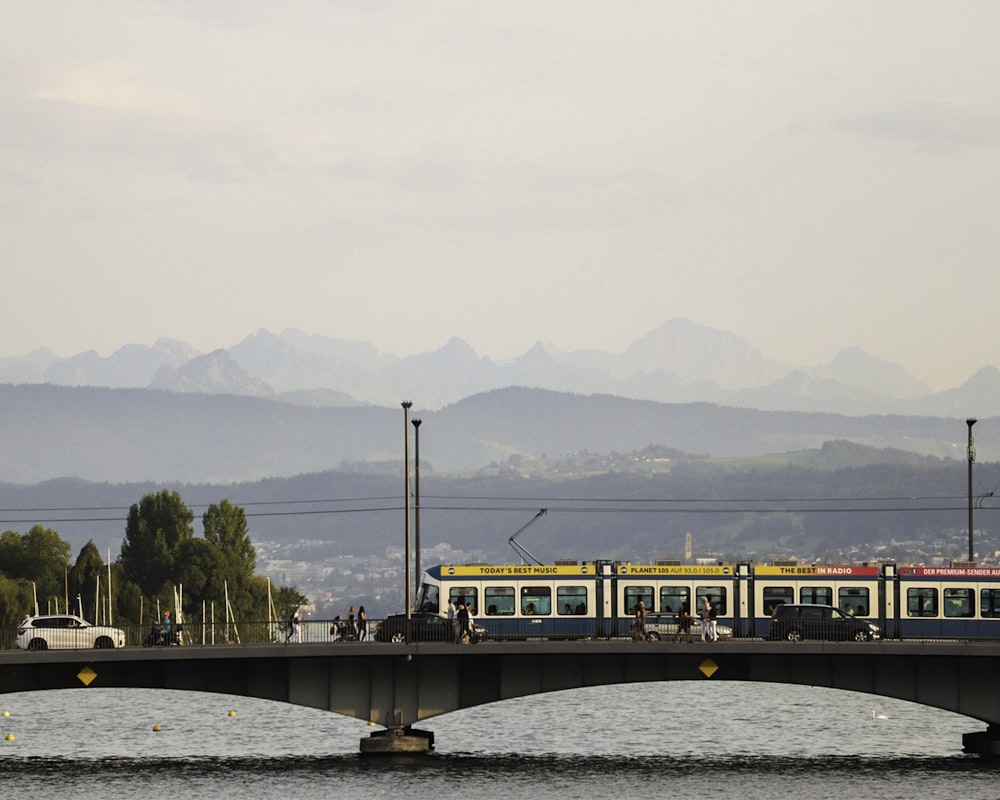 yellow and black train on bridge over river