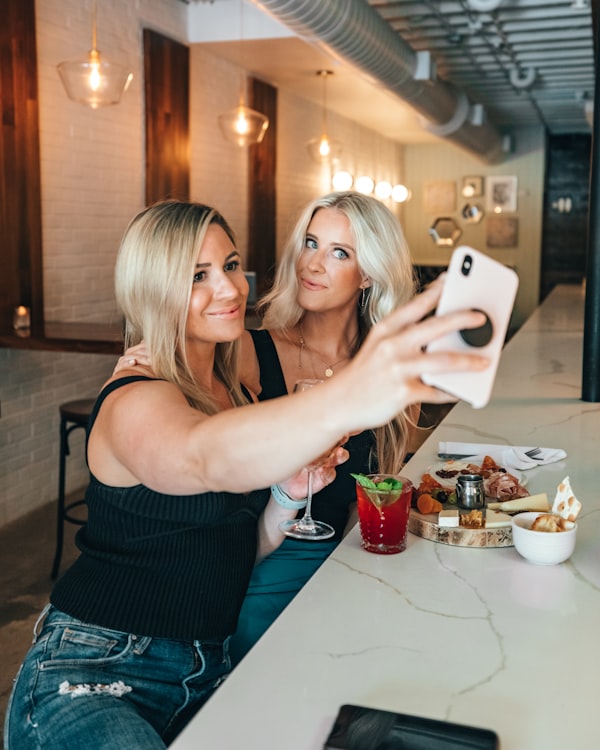 Two women posting lunch on social media
