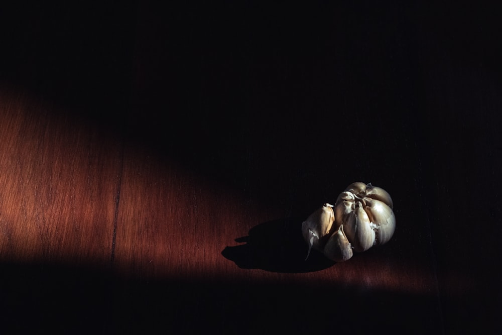 3 white garlic on brown wooden table
