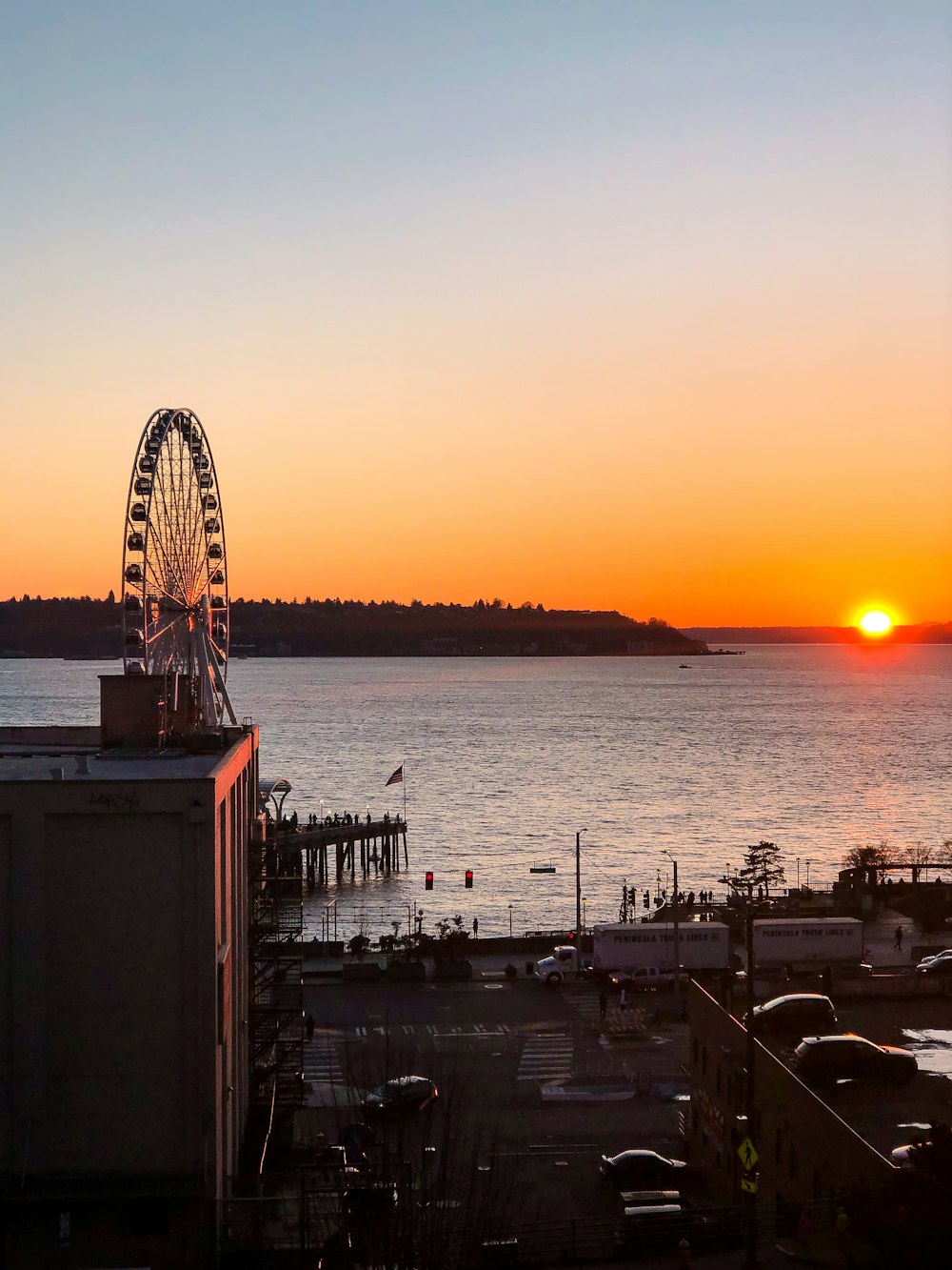 ferris wheel near body of water during sunset