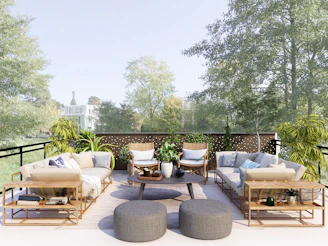 An inviting outdoor patio with comfortable seating and greenery surrounding it.