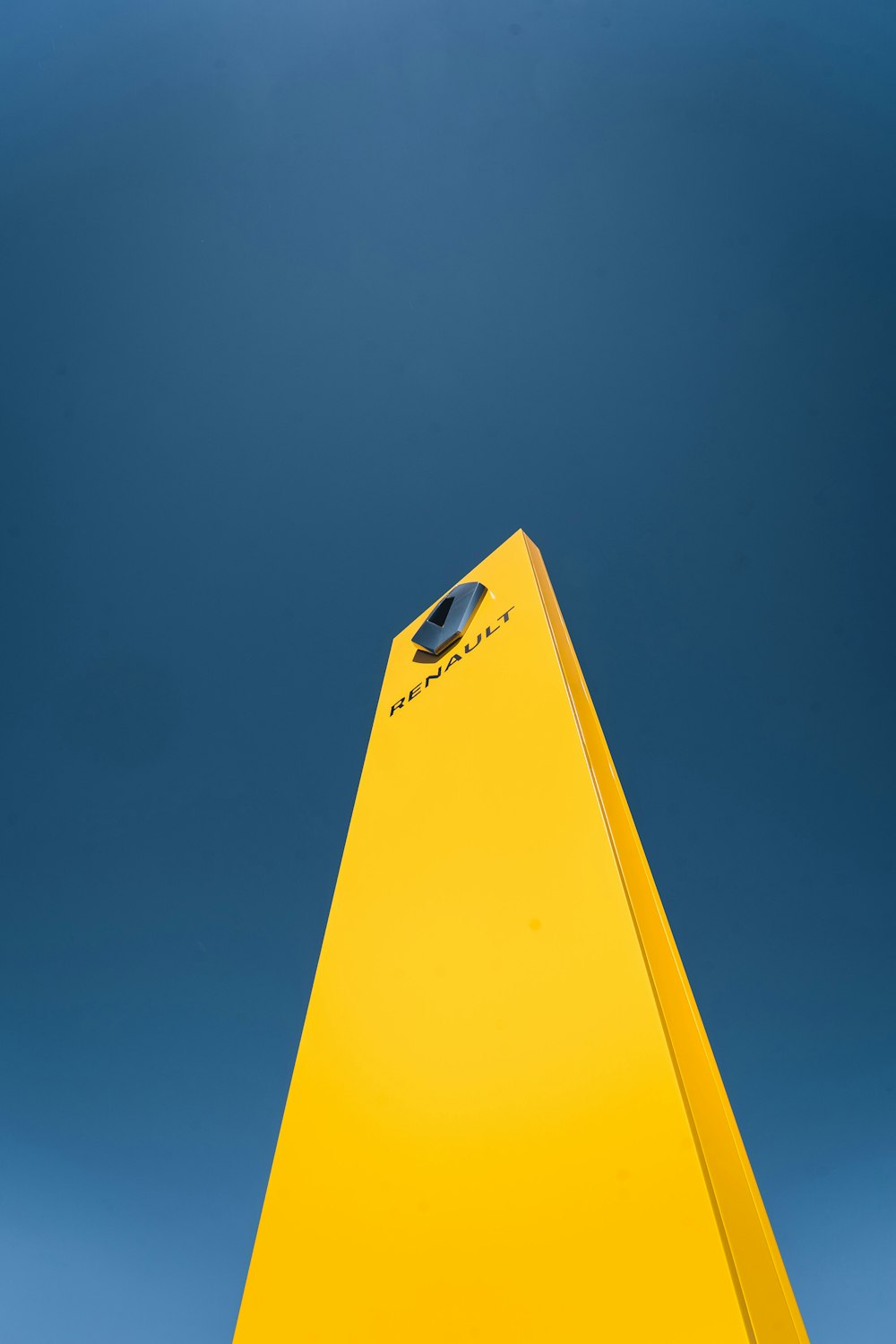 Avión de papel amarillo bajo el cielo azul durante el día