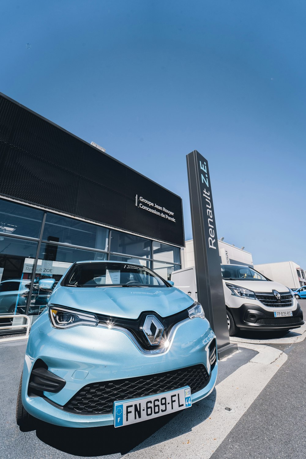 Voiture bleue et blanche garée près de l’immeuble