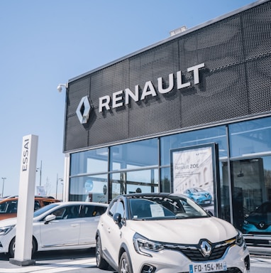 a white car is parked in front of a dealership