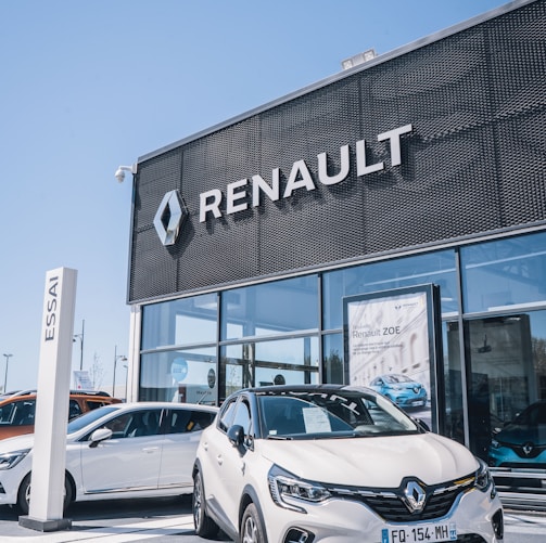 a white car is parked in front of a dealership