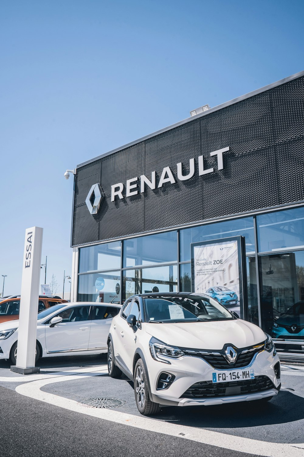 a white car is parked in front of a dealership