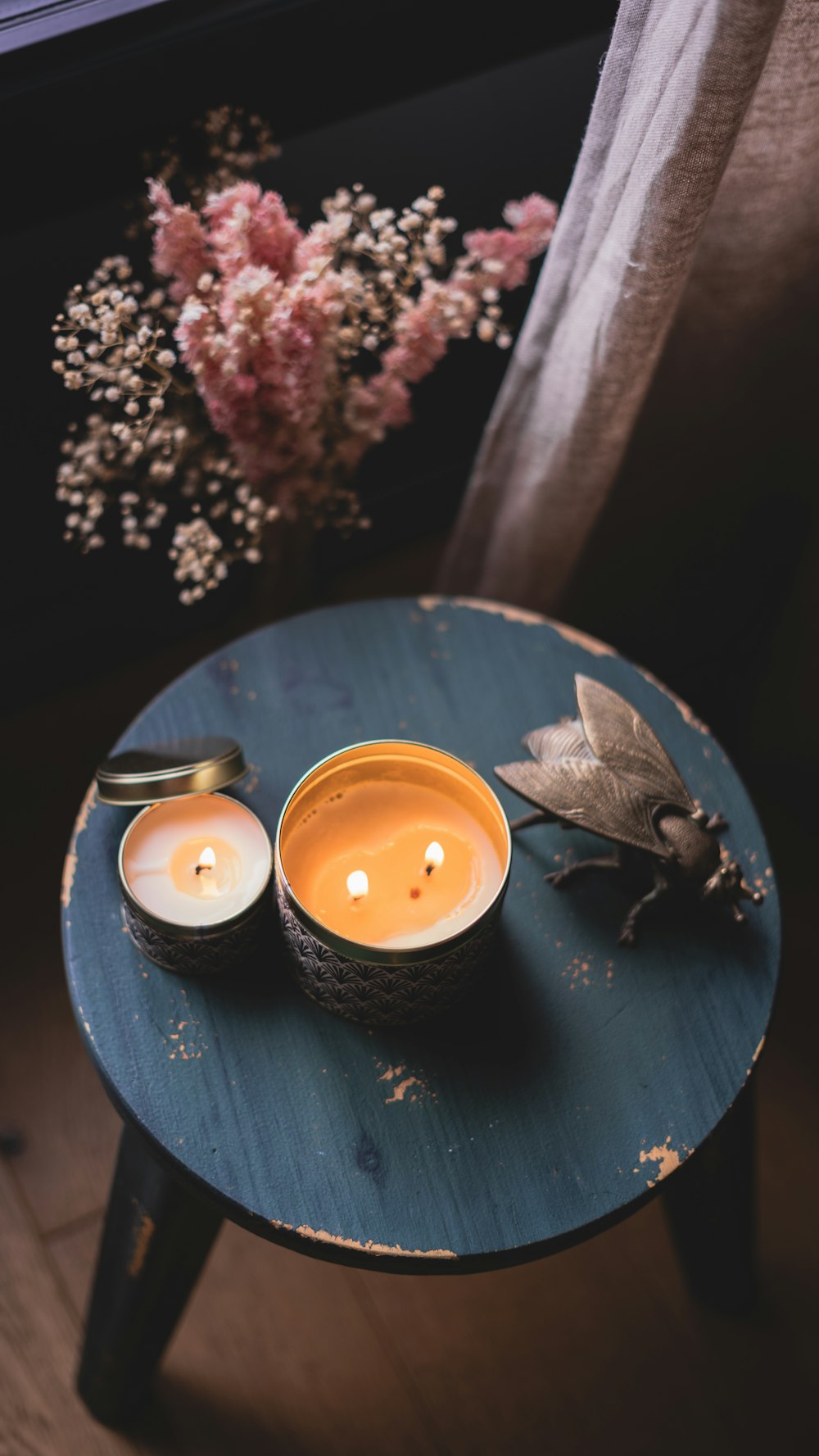 white pillar candle on black round plate