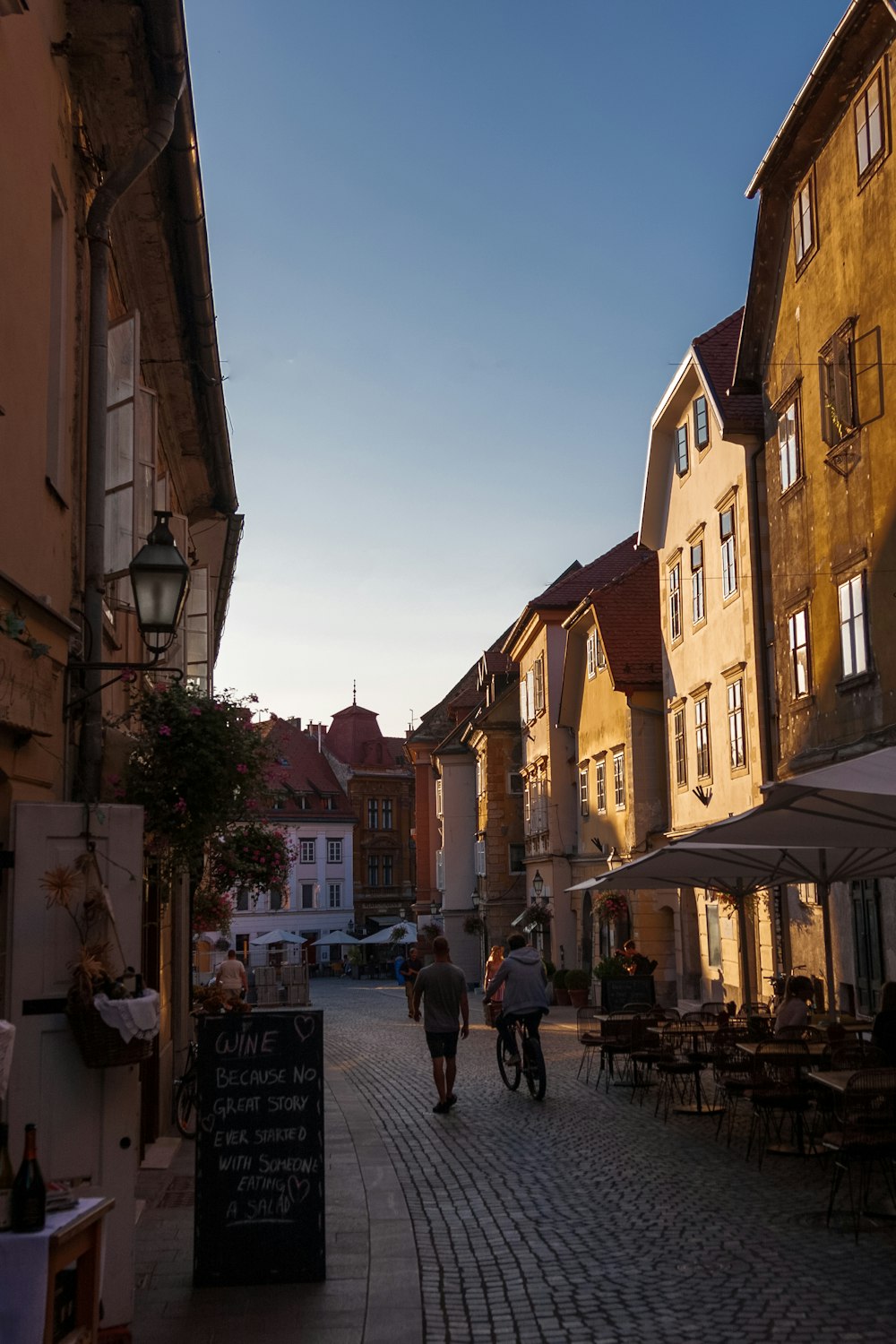 persone che camminano per strada tra gli edifici durante il giorno