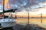 a sailboat docked at a dock with a bridge in the background