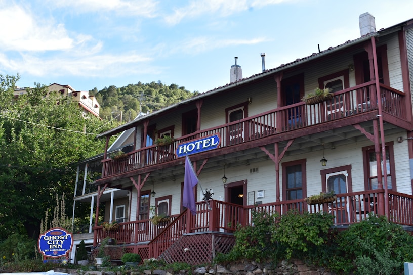 Rustic wooden facade of Hotel Pueblo Nuevo surrounded by lush greenery.