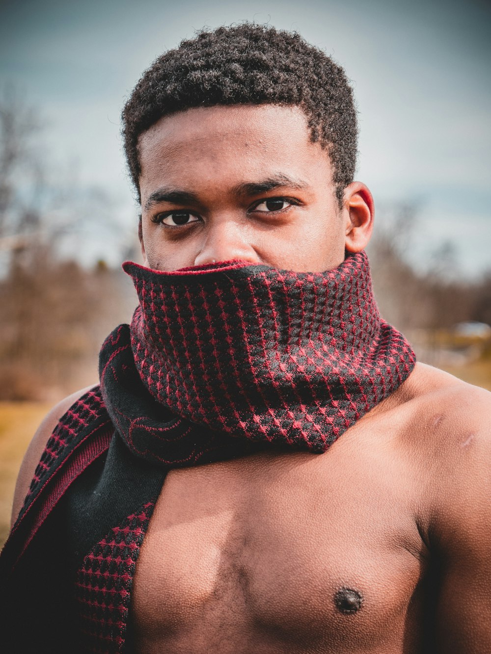 man covered with red and black scarf