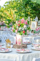 white and red flowers in white and pink floral vase on table