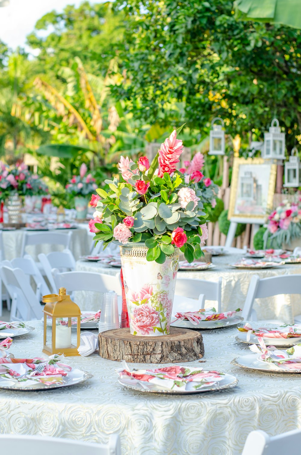 white and red flowers in white and pink floral vase on table