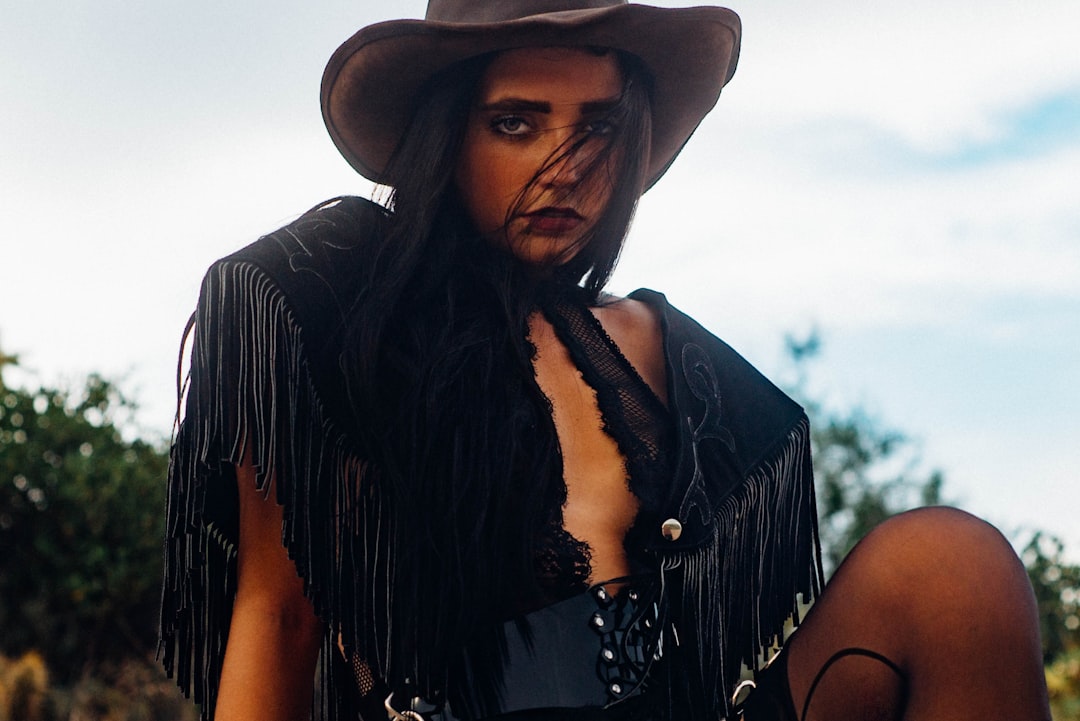 woman in black cowboy hat and black lace sleeveless top