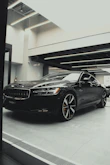 A sleek black car gleaming under soft lighting after a full exterior detail.