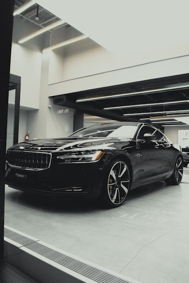 A sleek black S-Class limousine parked under soft golden lighting, reflecting luxury and comfort.