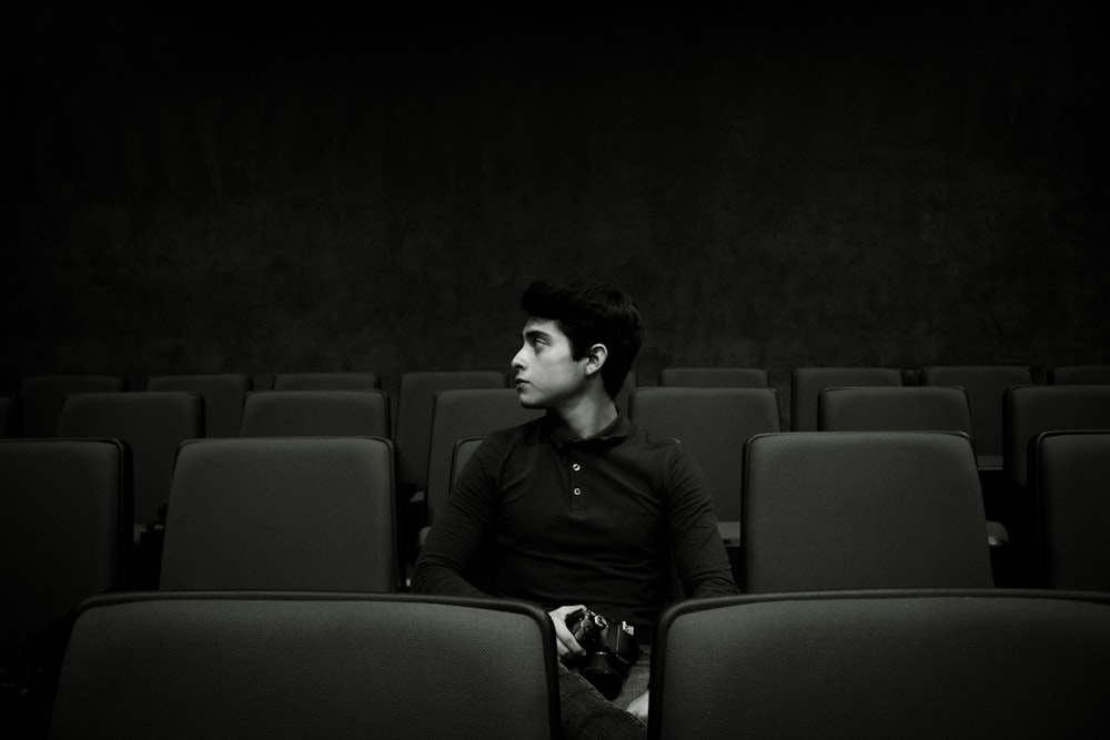 man in black jacket sitting on gray chair