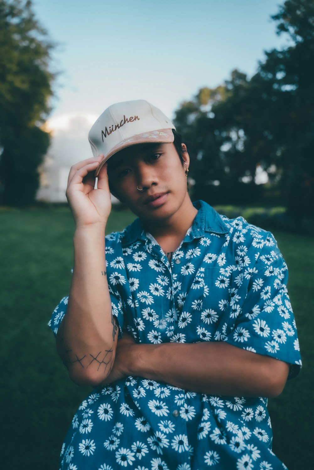 man in blue and white floral button up shirt wearing white cap