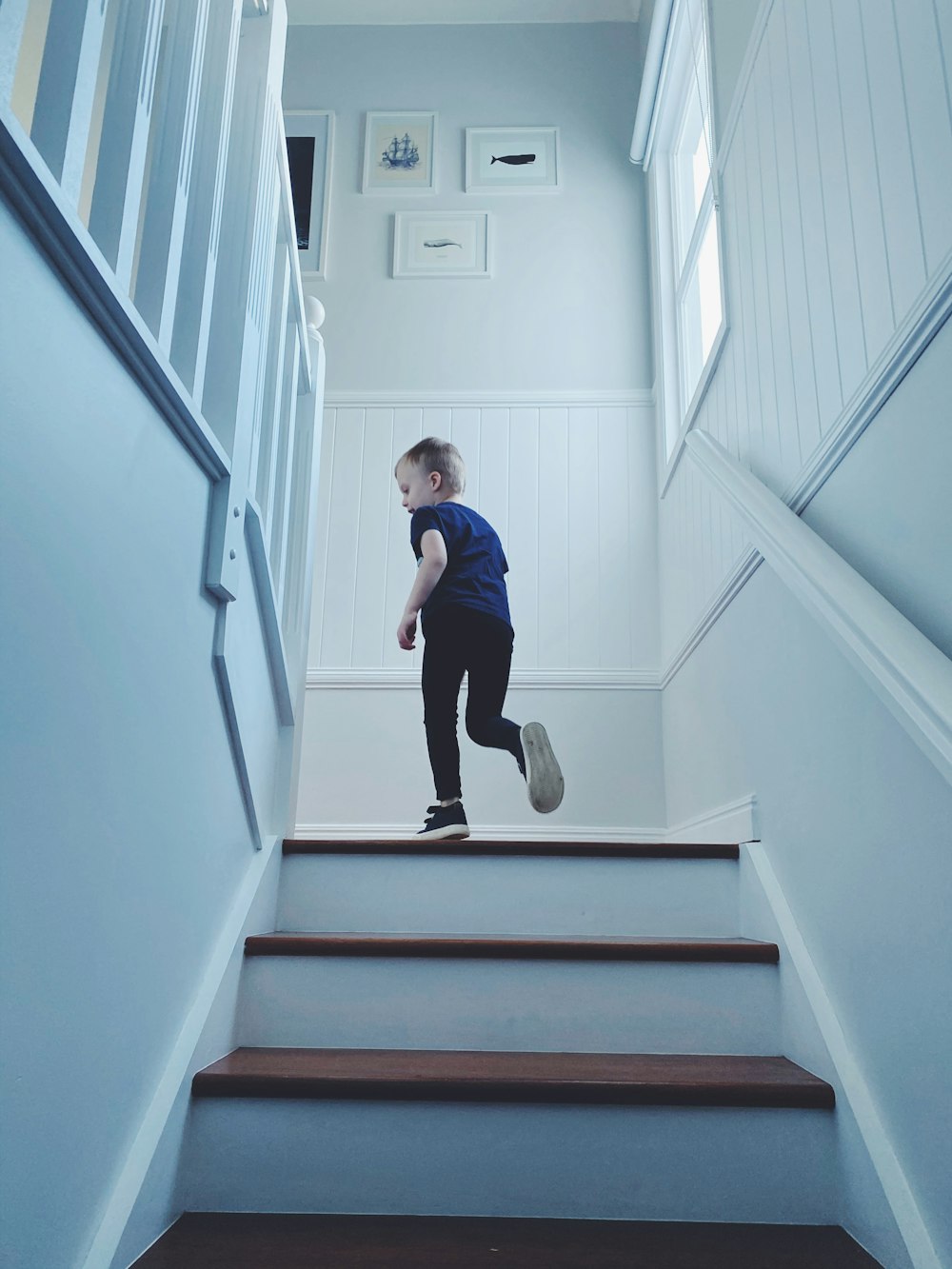 man in blue shirt and black pants sitting on white staircase