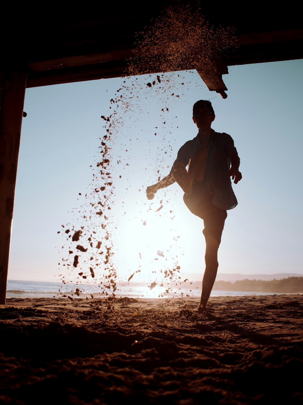 man in black jacket standing on beach shore during sunset