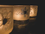 A set of pastel-colored candle holders glowing softly in a dim room.