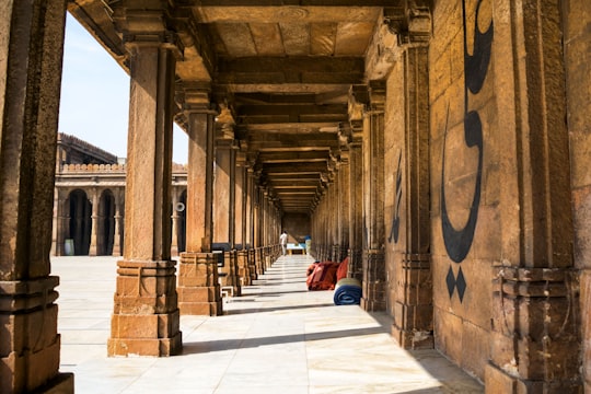 person in red jacket sitting on concrete floor during daytime in Ahmedabad India