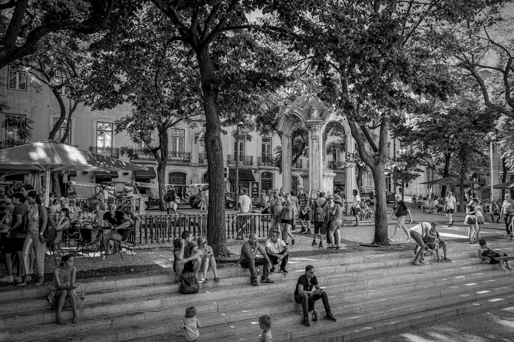 people sitting on bench in grayscale photography