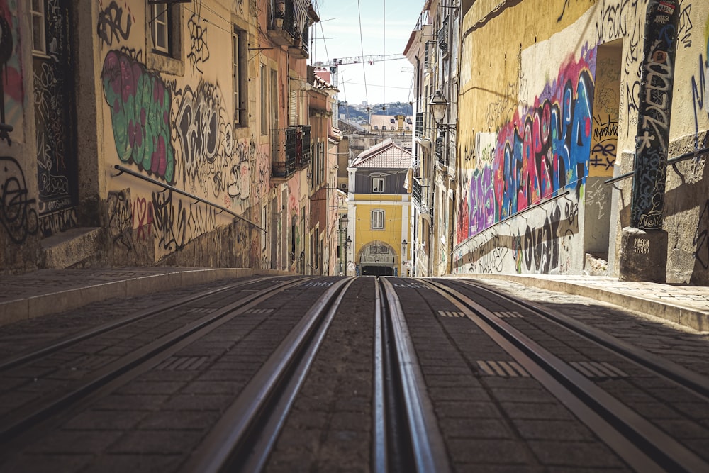 train rail in between concrete buildings during daytime