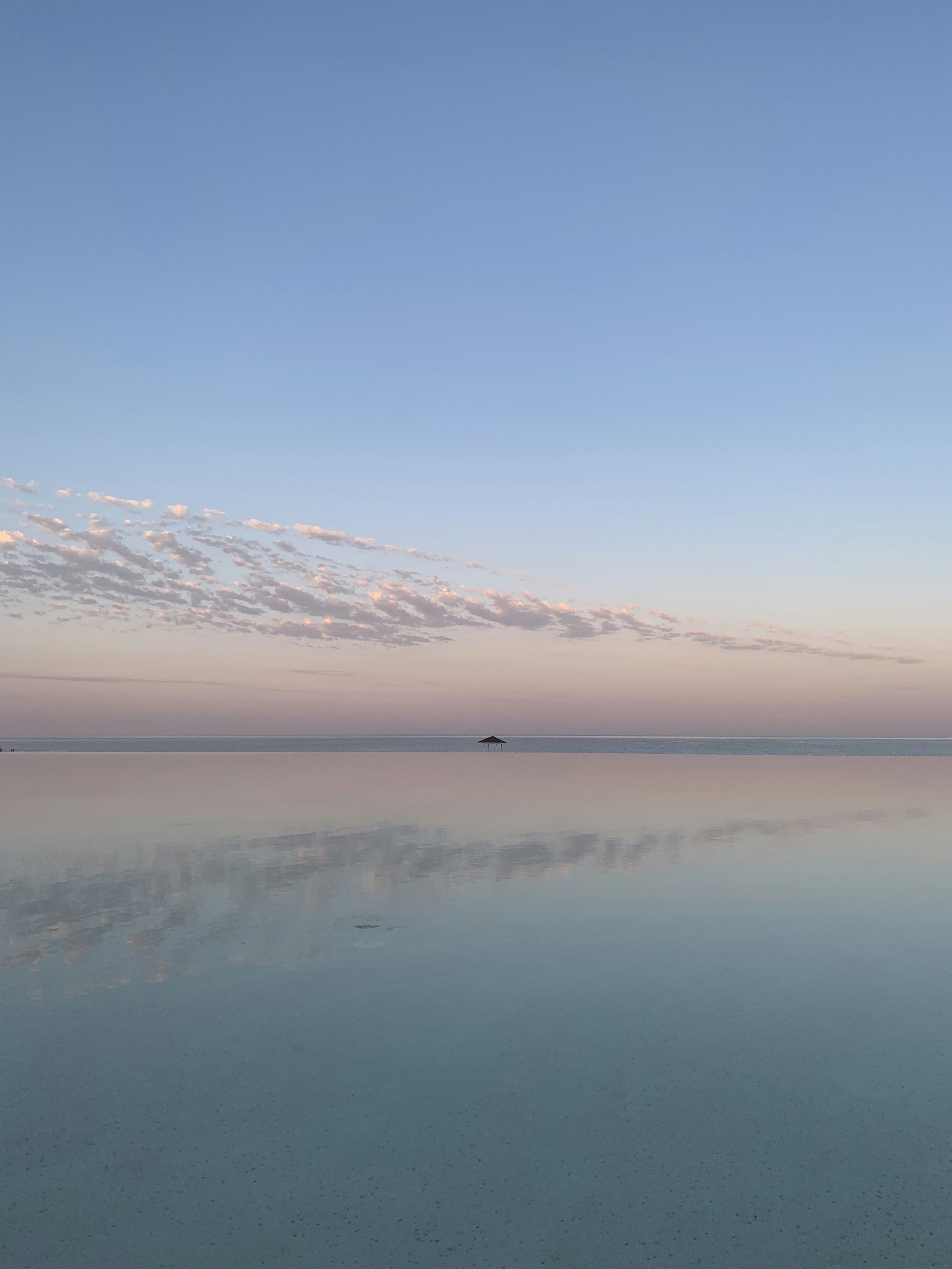 body of water near mountain under blue sky during daytime