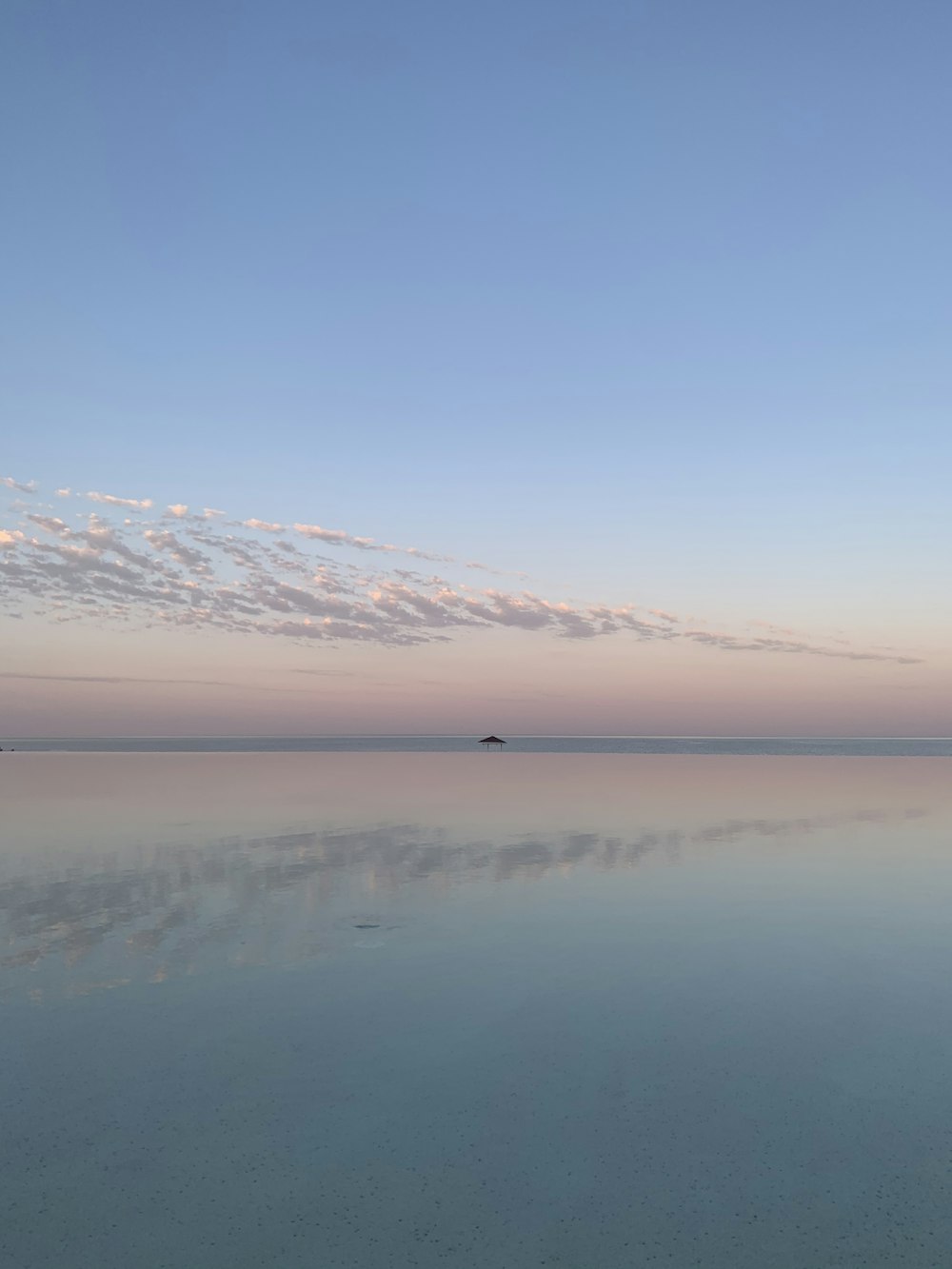 body of water near mountain under blue sky during daytime