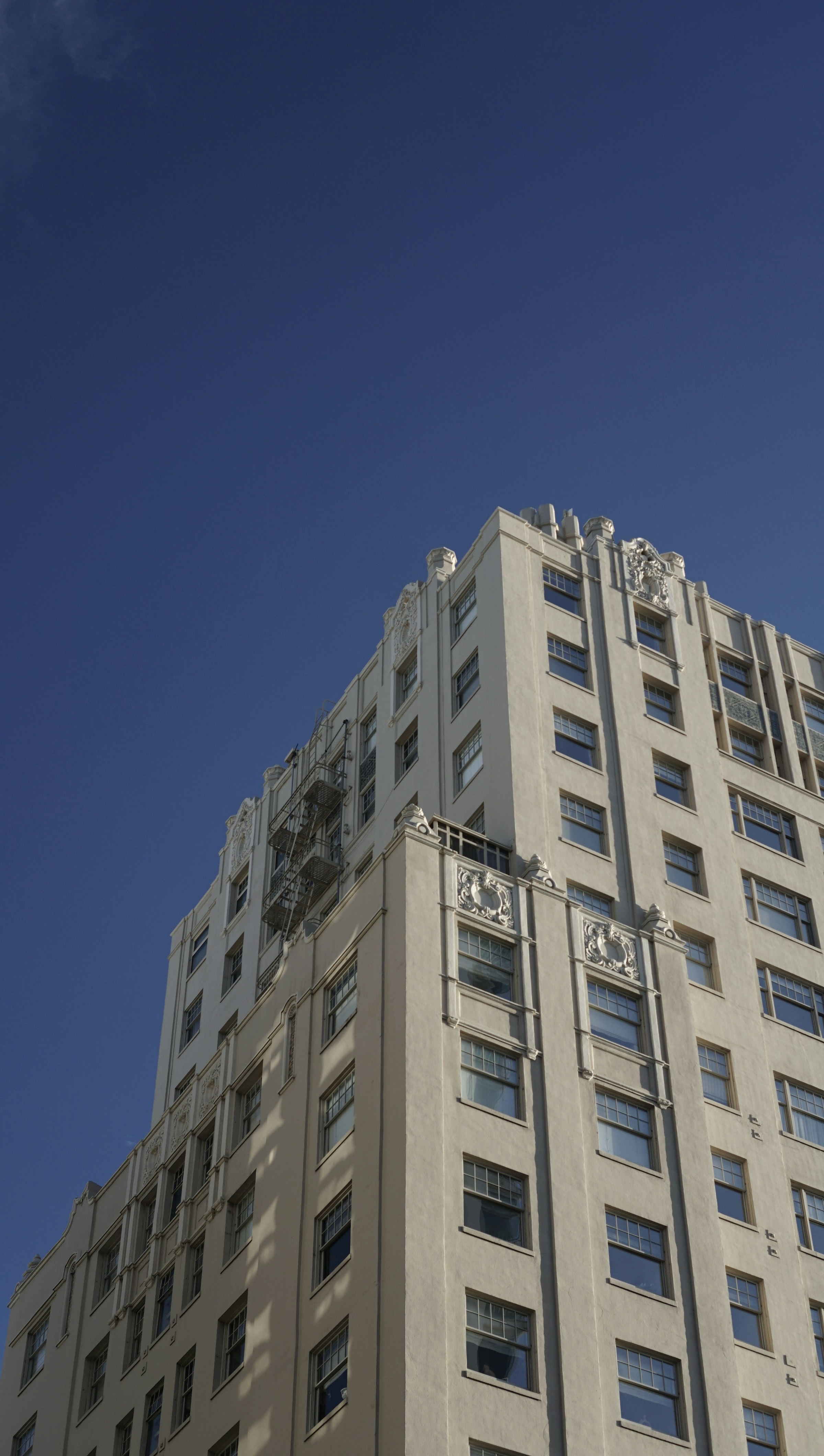 Weißes Betongebäude unter blauem Himmel tagsüber