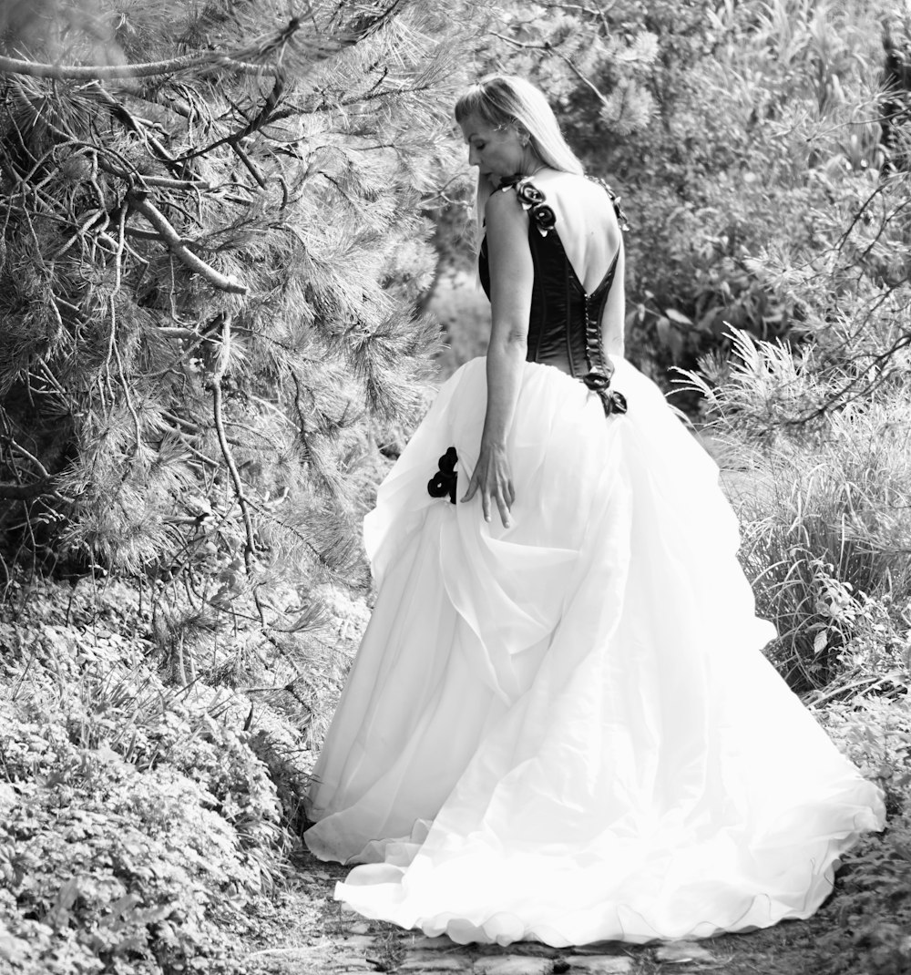 femme en robe de mariée blanche debout sur le sol