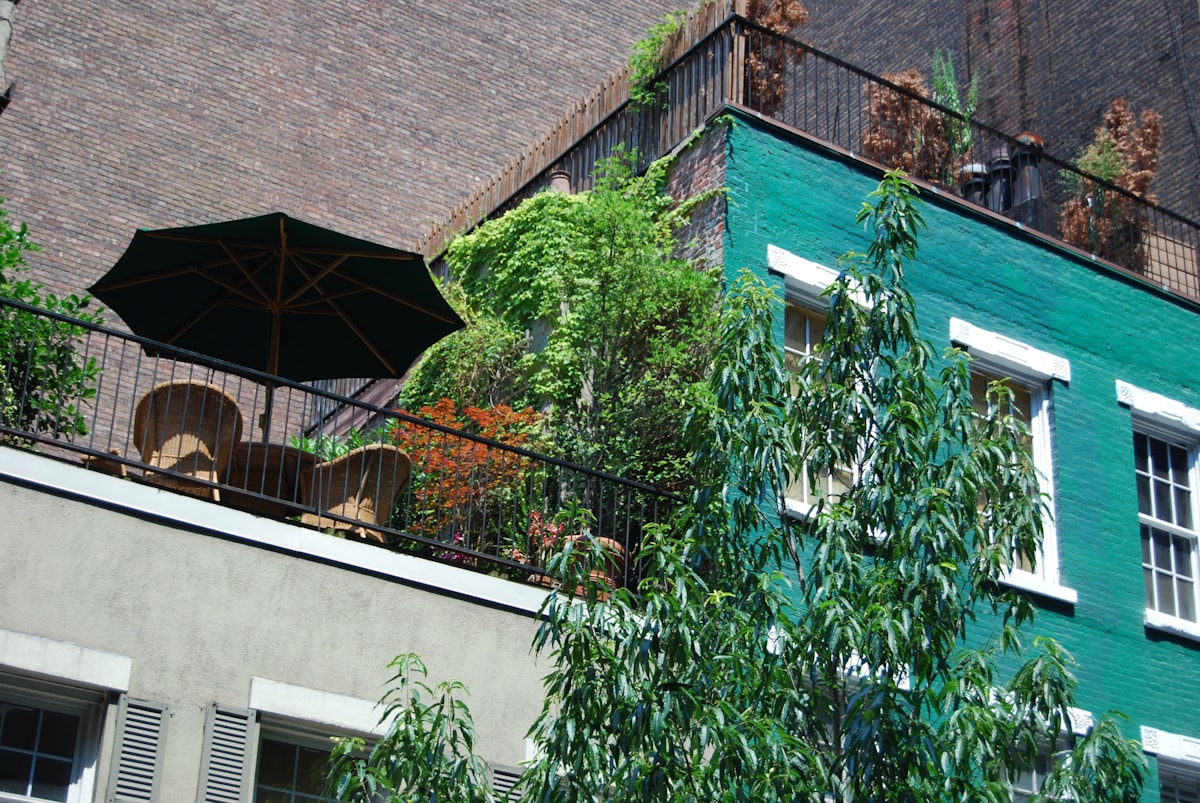 A balcony filled with lush green plants cascading over the railing