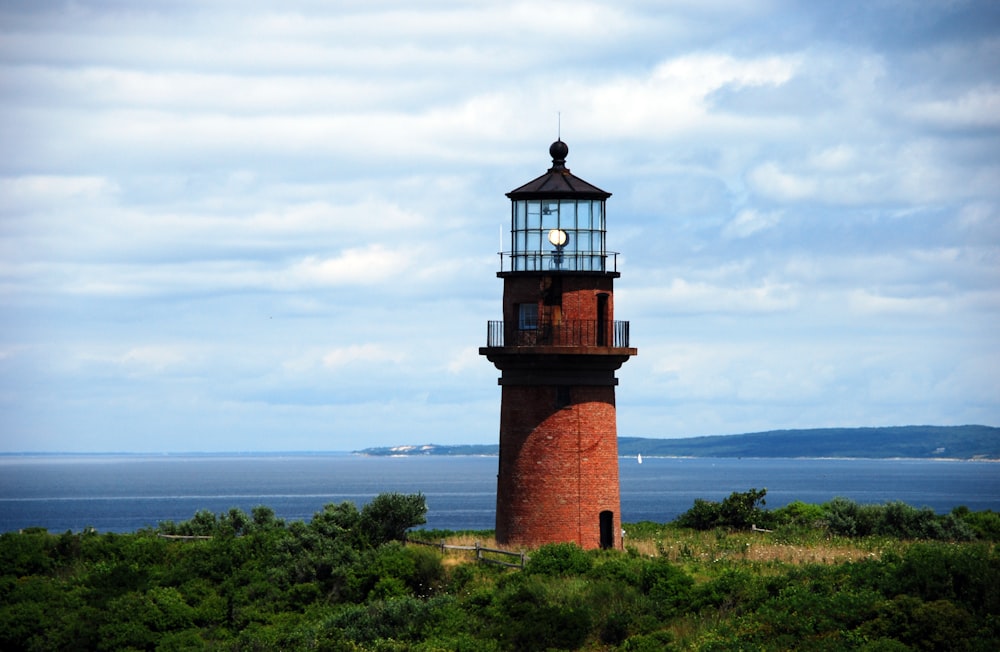 brown and black concrete lighthouse under blue sky during daytime