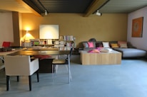 A cozy living room with modern furniture where residents are studying and sharing stories.