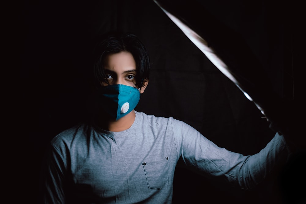 woman in gray long sleeve shirt wearing blue mask