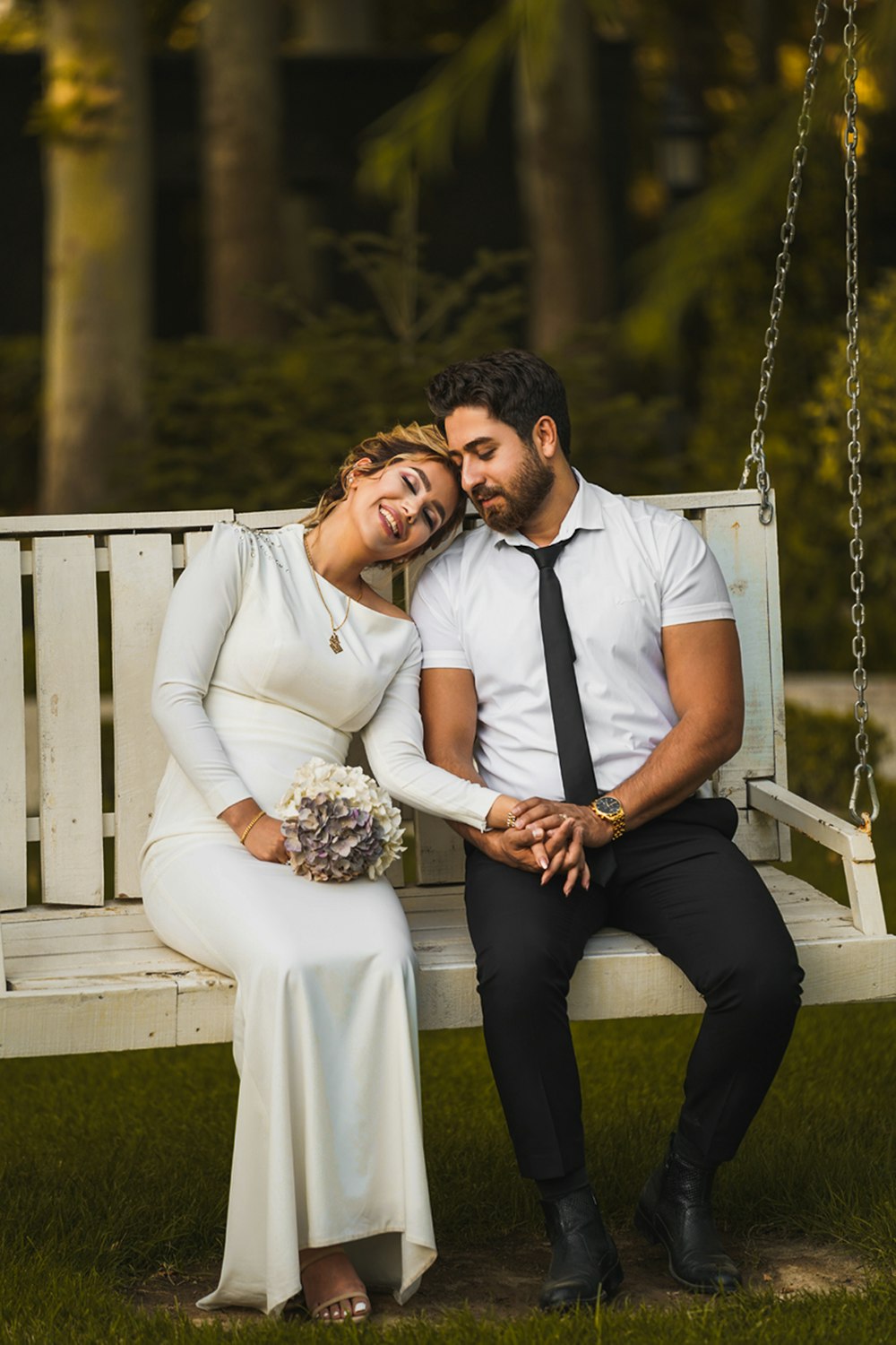 man and woman sitting on white wooden bench during daytime