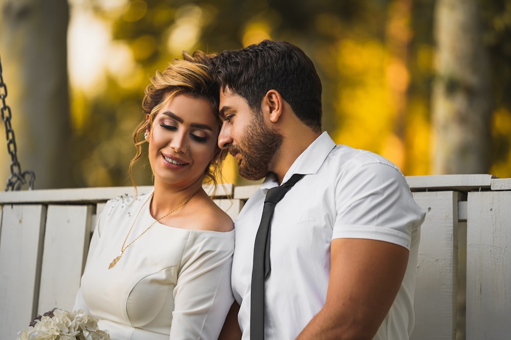 man in white dress shirt hugging woman in white dress