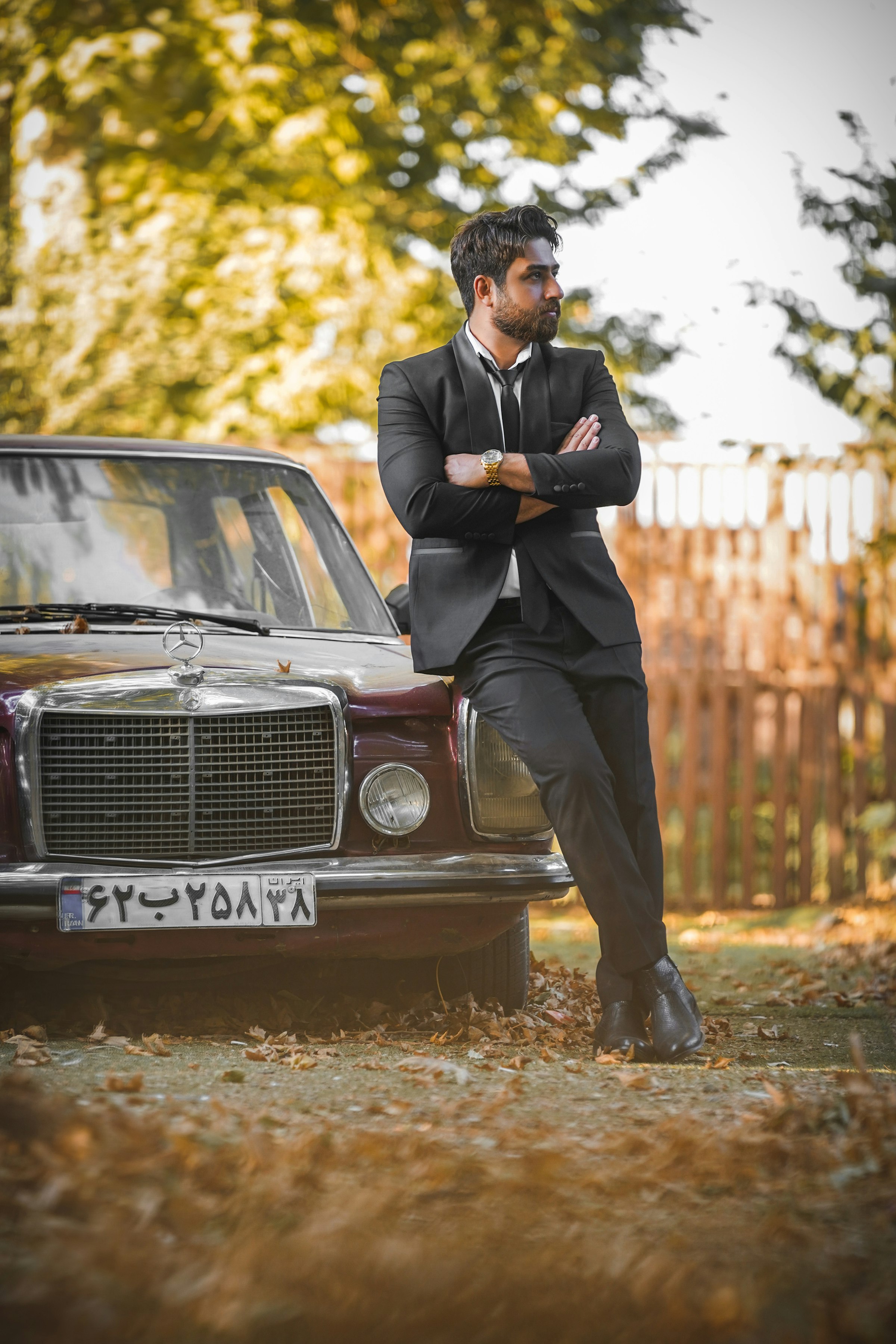 Chauffeur in a black suit waiting beside a black Mercedes-Benz